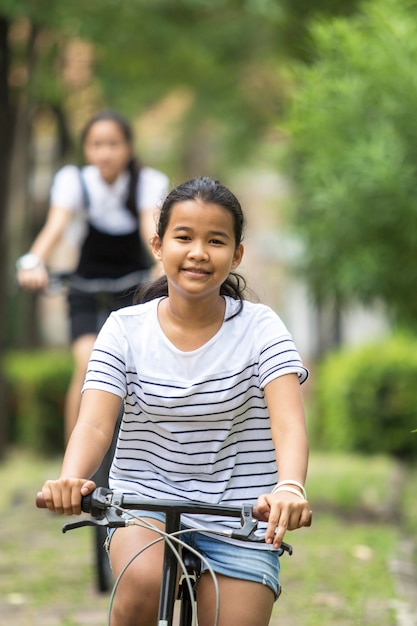 Asian teenager riding a bicycle in green public park