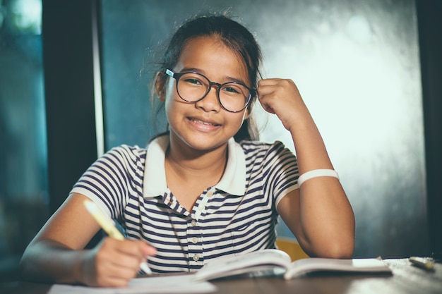 사진 학교 책 전경의 스택과 함께 집에 일을하는 안경을 착용 아시아 십대