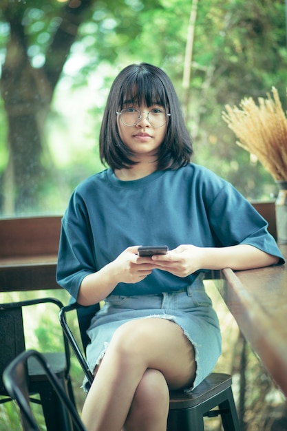 Asian teenager with smartphone in hand