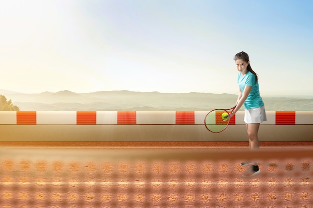 テニスラケットとボールを手にボールを持つアジアのテニスプレーヤーの女性