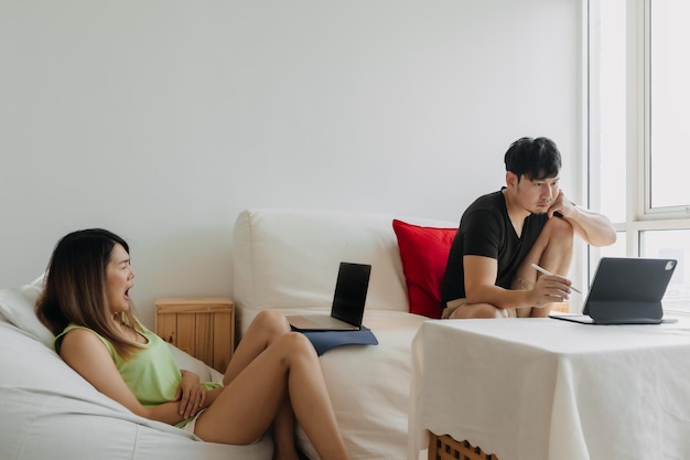 Photo asian thai couple using laptop both man and woman busy working on notebook lover freelancer sitting