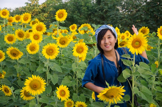 Asian thai woman travel and posing for take photo at sunflower flower field in morning time at Saraburi Thailand