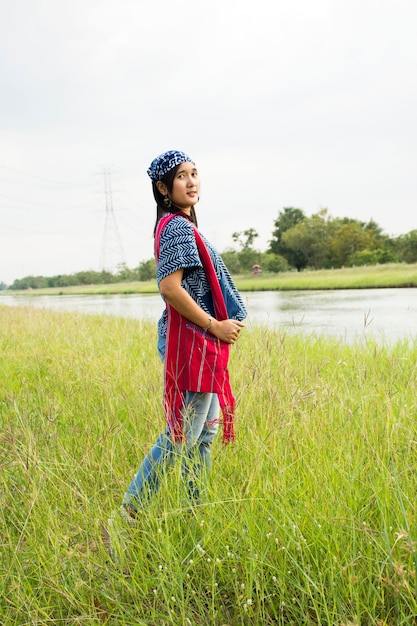 Donna tailandese asiatica che indossa abiti di moda indaco in posa ritratto per scattare foto all'aperto nella campagna di nonthaburi thailandia