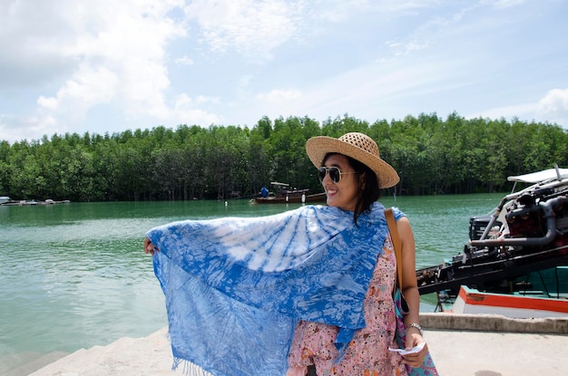 Asian thai women relax and playing indigo tie dye fabric shawl on the harbour at Bang Rong Pier for go to Koh Yao Noi Island in Phuket Thailand