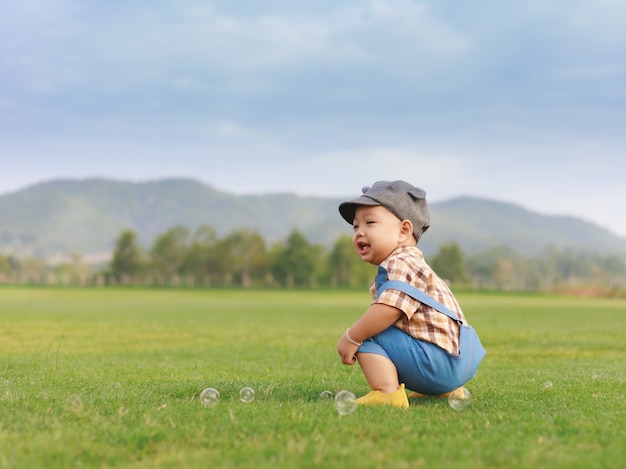 Ragazzo asiatico del bambino che gioca nel parco naturale