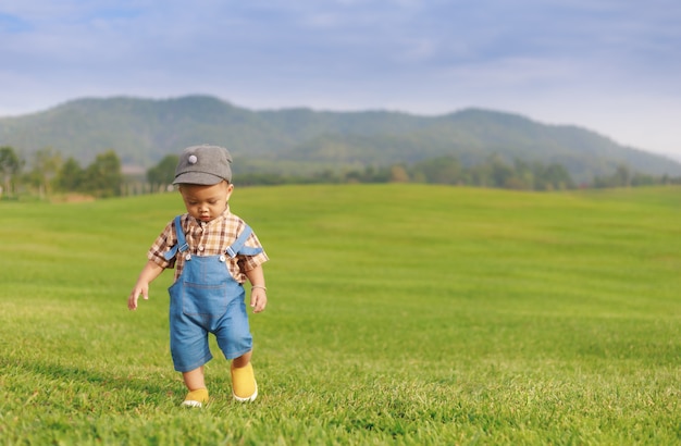 Ragazzo asiatico del bambino che gioca nel parco naturale