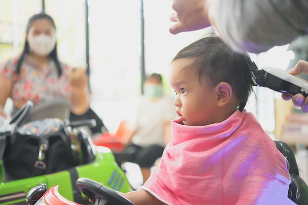 Asian Toddler child getting his first haircut.