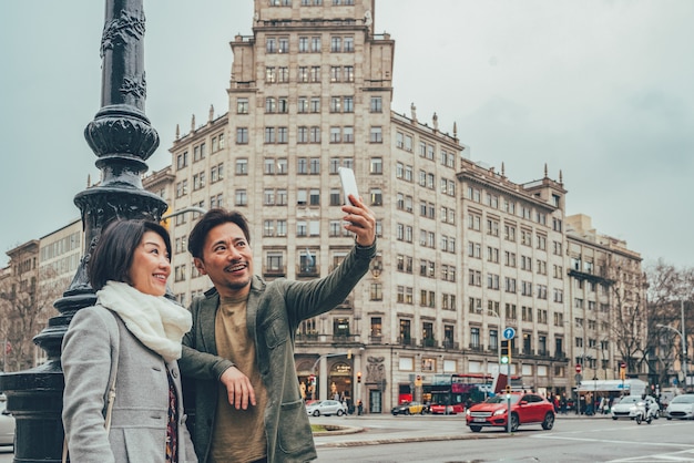 Asian tourist couple taking a selfie on the mobile phone