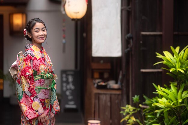 写真 日本の京都市の古い寺院を歩く伝統的な着物を着たアジア人の旅行者の女の子