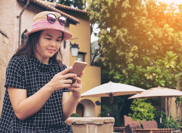 Asian traveler using smartphone while traveling in Europe.