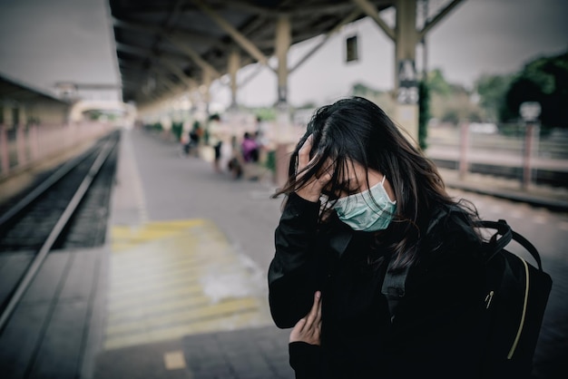 La donna asiatica del viaggiatore indossa la maschera per proteggere il coronavirusla donna tailandese che indossa la maschera facciale protegge le vie respiratorie e filtra il particolato pm25