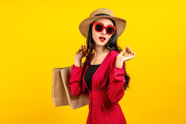 Asian trendy shopaholic woman excited about new purchases or sales holding shopping bags and looking