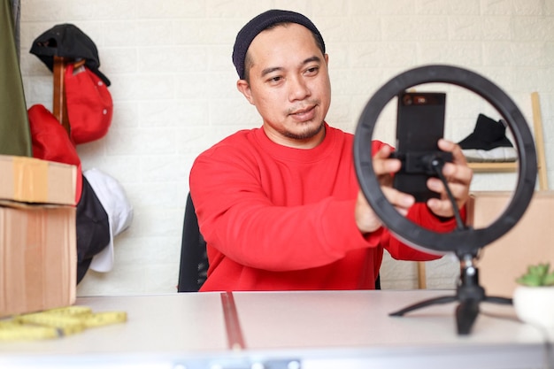 Asian vlogger man setting smartphone for live streaming Social media Influencer and online shoppi