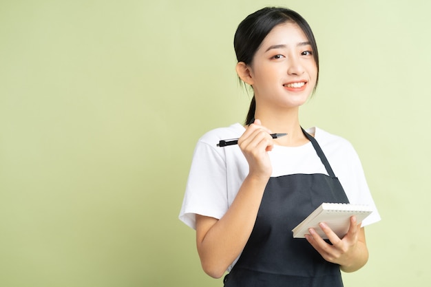 Photo asian waitress holding a note in hand