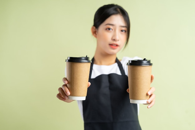 Asian waitress holding two cups of coffee