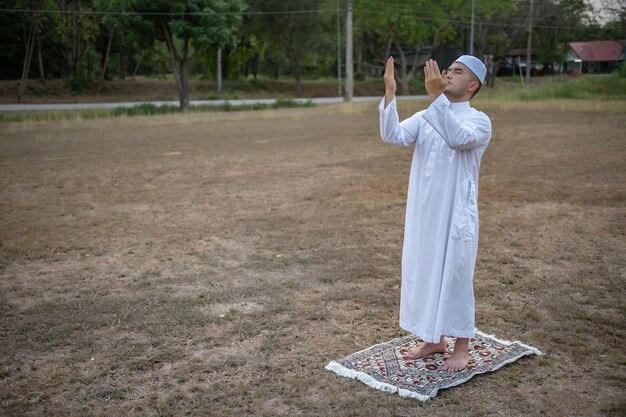 アジアの白人イスラム教徒の男の祈り若いイスラム教徒の祈りラマダン祭りのコンセプト