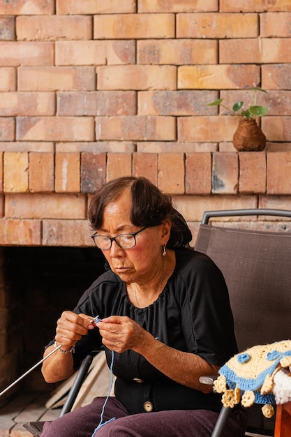 Foto sapienza asiatica nel tessere artigianato di signore anziane a casa