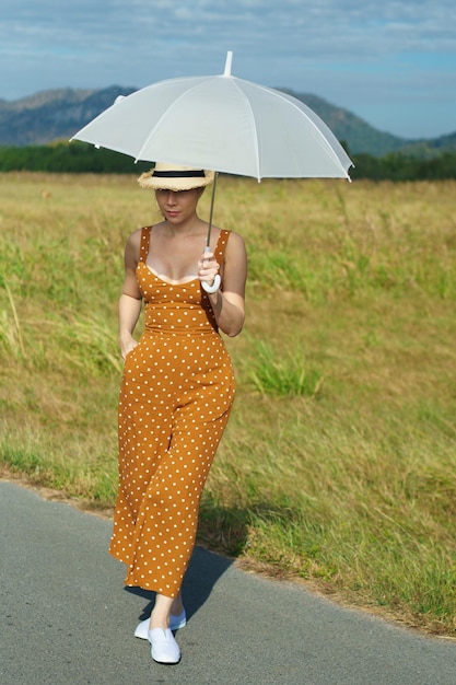 Asian Woman 40s LGBT transgender express feeling Happy Smile fun under sunshine on empty street road and flower field over blue sky mountain Female poses for fashion shooting in outdoors landscape