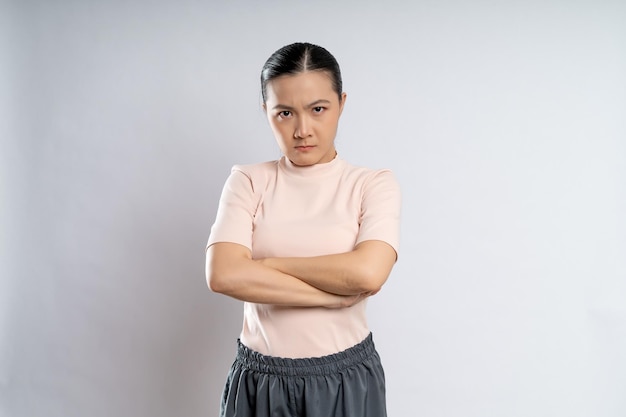 Donna asiatica arrabbiata in piedi su sfondo isolato