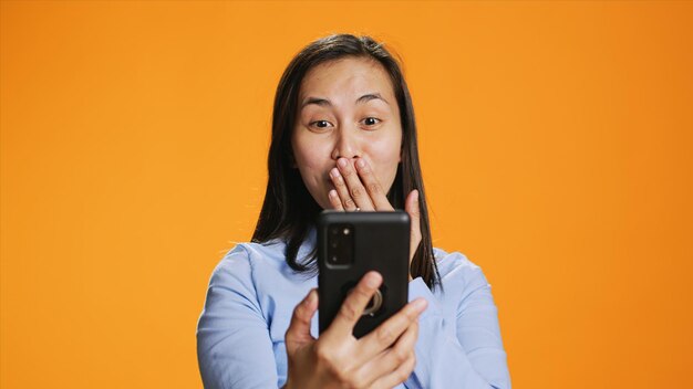 Asian woman answers online videocall in studio