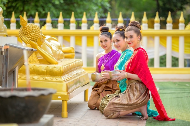 Asian woman are bathing Buddha statue happily in thailand.