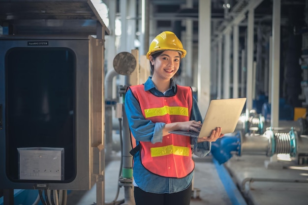 Asian woman are engineer factory inspecting machine in factory with computer Asian woman engineer working in factory concept