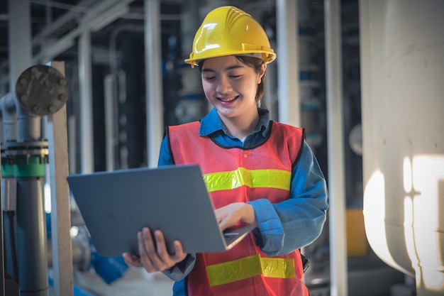 Asian woman are engineer factory inspecting machine in factory with computer Asian woman engineer working in factory concept