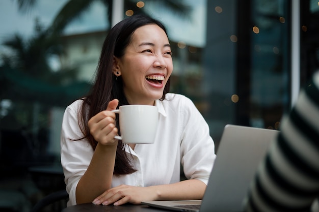 写真 ラップトップに取り組んでいるカフェでアジアの女性