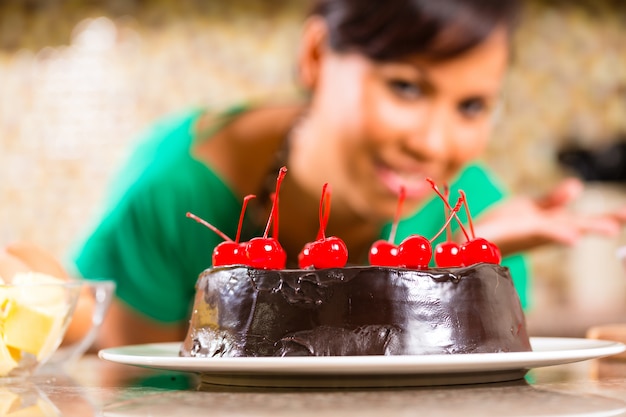 アジアの女性がキッチンでチョコレートケーキを焼く