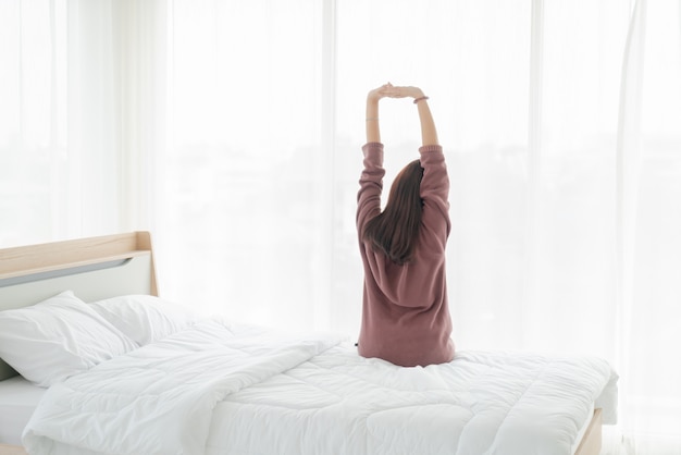 Asian woman on bed and waking up in the morning