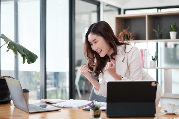 Asian woman blogger wear white suit exciting and talking with\
followers, live streaming on social media application. freelance\
work from home concept.