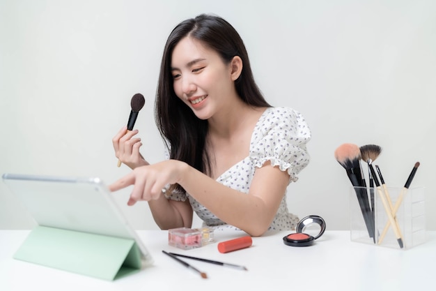 Asian woman bloggers are reviewing cosmetics. and teach makeup through tablet