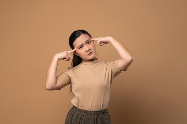 Asian woman bored and annoyed feel confuse standing isolated on beige background