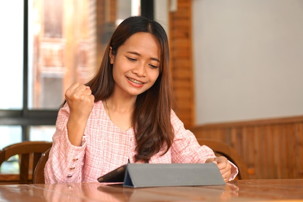 Asian woman braces watch computer Glad that the business results are profitable