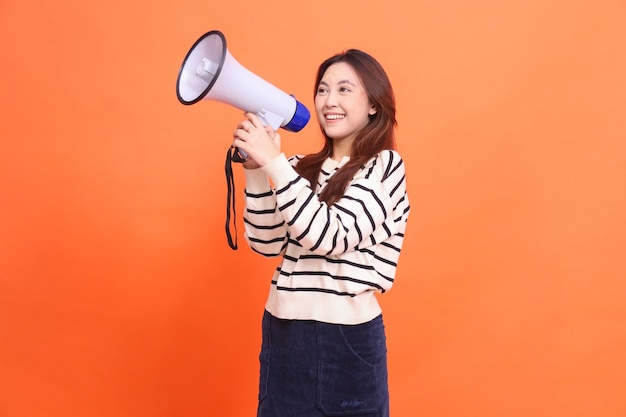 Asian woman candid smile shouting expression standing with two hands holding megaphone loudspeaker f