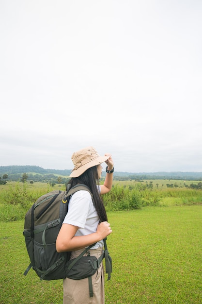 Donna asiatica che porta una borsa da trekking concetto di zaino in spalla e bella donna asiatica che guarda di traverso