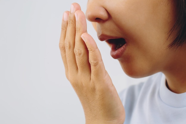 Asian woman checking her breath with hand test Health Care concept