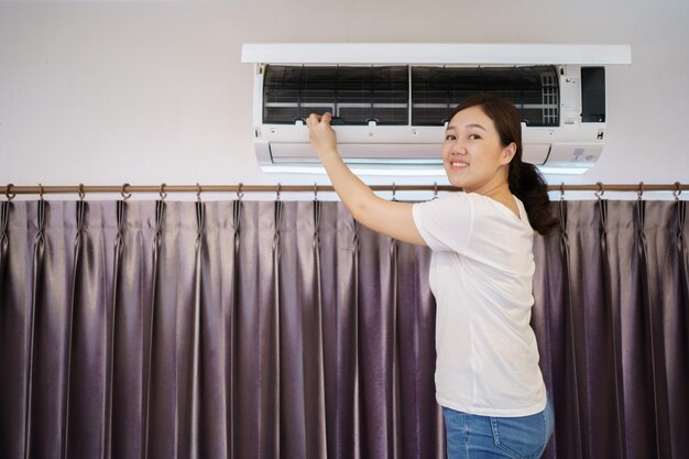 Asian Woman Cleaning A Dirty And Dusty Air Conditioning Filter In Her House Housewife Removing A Dusty Air Conditioner Filter