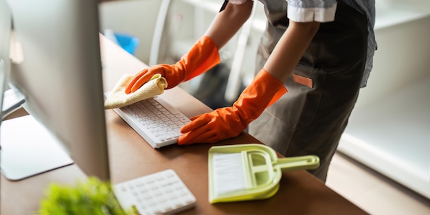 写真 アジア人女性が自宅の作業室を掃除する 若い女性の主婦 掃除者は作業用の機器を拭くために布を使用します 掃除のコンセプト 家事掃除