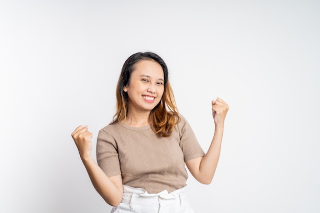 Asian woman clenching hands while celebrating success