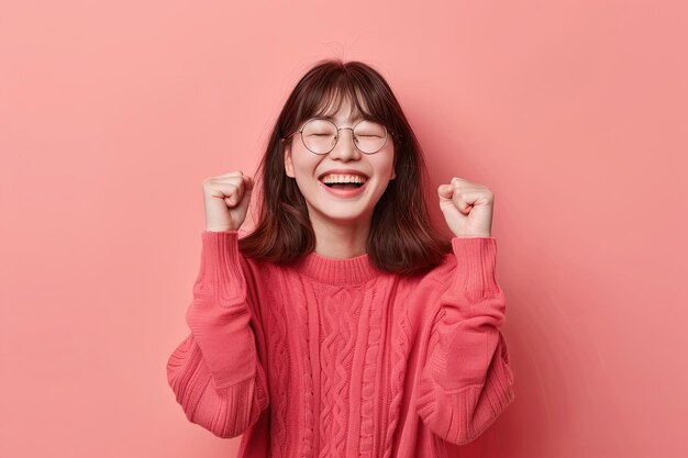 Photo asian woman clenching her hands with a happy expression