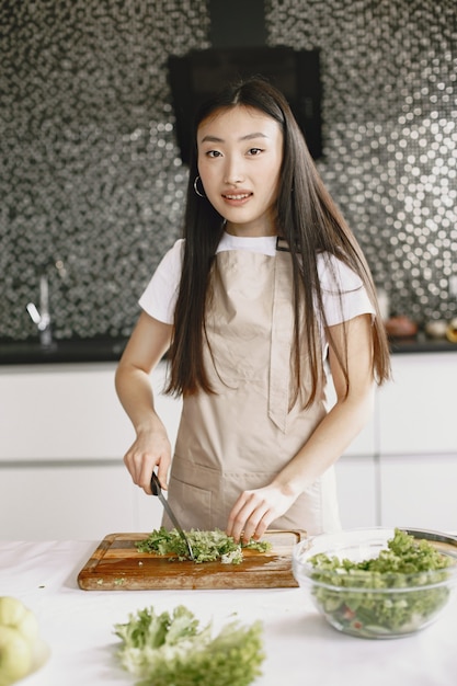 家で料理をするアジアの女性。