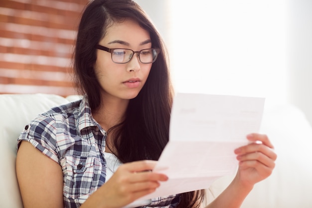 Asian woman on the couch reading letter