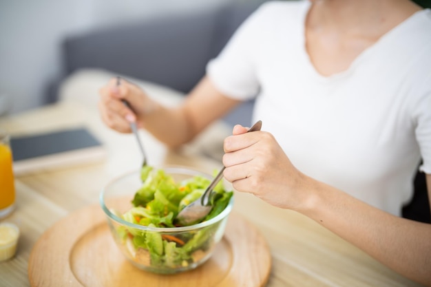 Donna asiatica a dieta perdita di peso mangiare insalata fresca fresca fatta in casa concetto di alimentazione sana