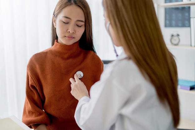 Donna asiatica medico cancro al seno sintomi fattori di rischio e controllo del trattamento per il paziente nell'ufficio della clinica