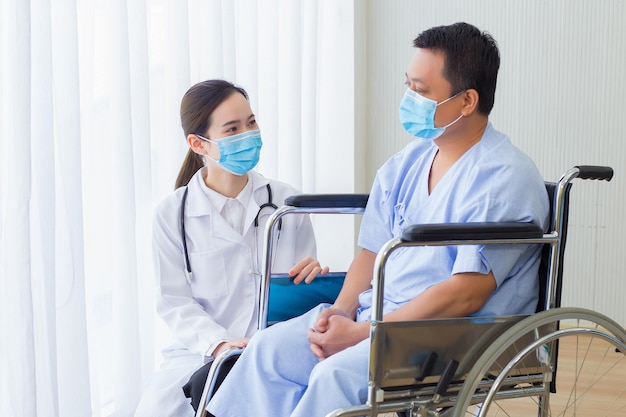 Asian woman doctor explain and suggest some information with a\
man patient in hospital.