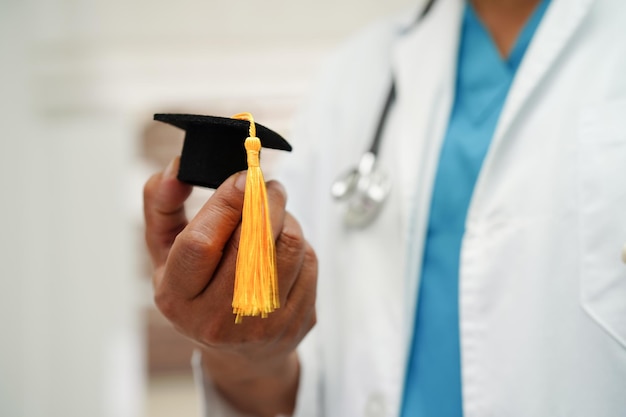 병원 의료 교육 개념에서 졸업 모자를 들고 아시아 여자 의사
