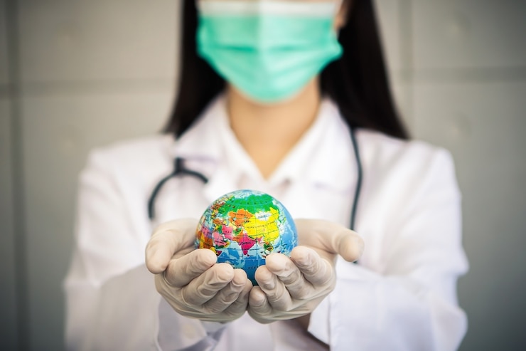 Photo asian woman doctor wears medical coat face mask and rubber glove while holds global ball