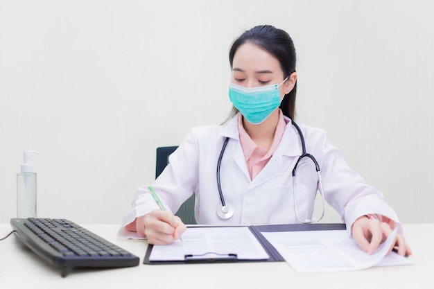 Asian woman doctor wears medical face mask while she working at hospital to protect Coronavirus disease 2019 (Covid 19) epidemic.