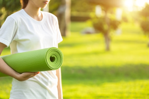 Asian woman doing yoga exercises in the park